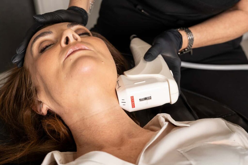 a woman receives HIFU treatment on her neck